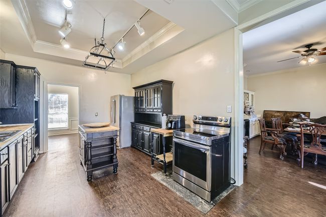 The kitchen opens to the front room (straight ahead) and the hospitality room (right). | Image 18