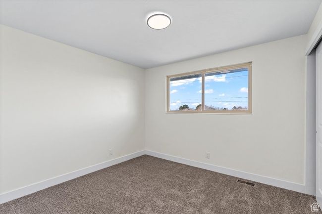 Unfurnished room featuring baseboards, visible vents, and dark carpet | Image 12