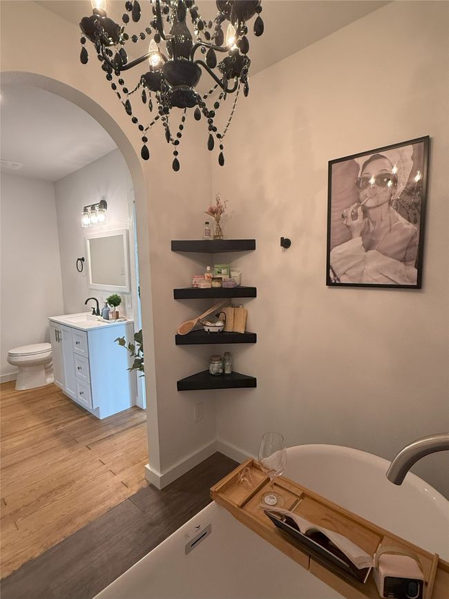 Bathroom featuring a soaking tub, vanity, and wood finished floors | Image 25