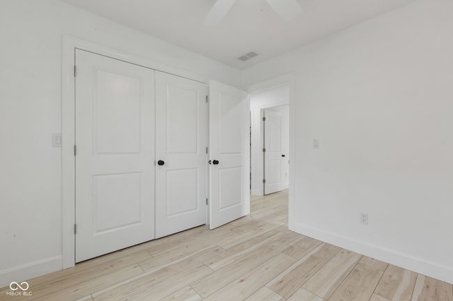 unfurnished bedroom featuring a closet, baseboards, light wood-style flooring, visible vents, and ceiling fan | Image 51