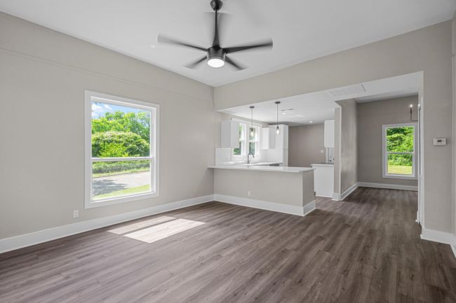Unfurnished living room with dark wood finished floors and ceiling fan | Image 9