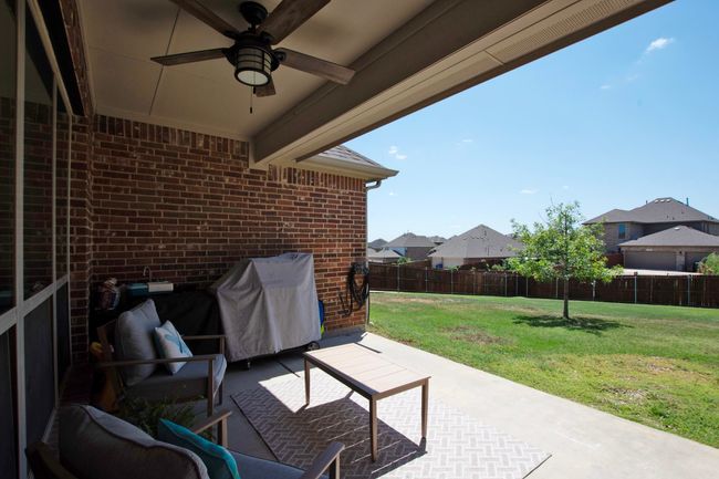 View of patio featuring a fenced backyard, ceiling fan, and a residential view | Image 35