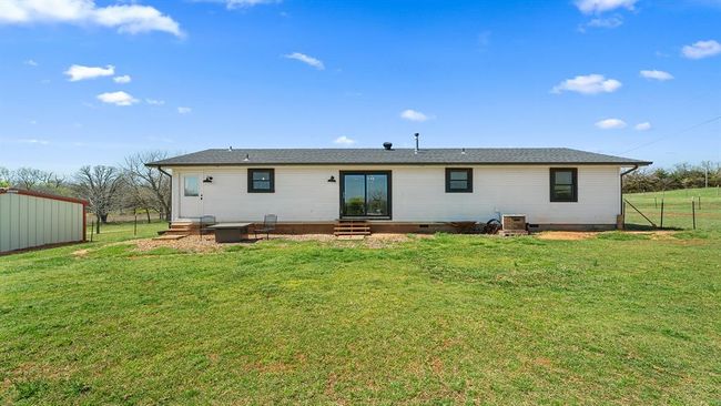 Rear view of house featuring entry steps, fence, and a lawn | Image 16