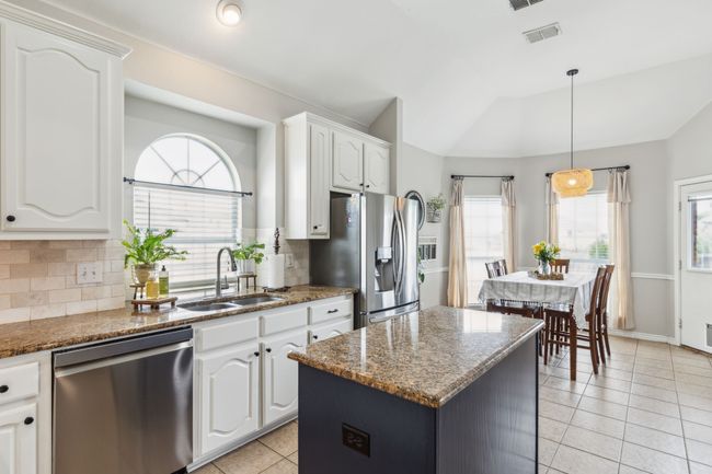 Kitchen featuring a sink, stainless steel appliances, a wealth of natural light, tasteful backsplash, and vaulted ceiling | Image 12