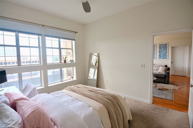 Carpeted bedroom with ceiling fan and wood finished floors | Image 38