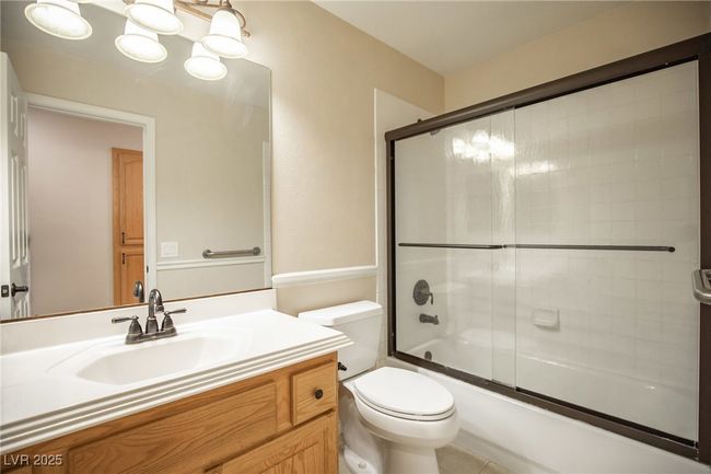 Bathroom featuring shower / bath combination with glass door, toilet, and vanity | Image 26