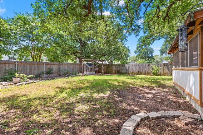 Along the back fence, a charming pergola adds a little structure and flair, perfect for string lights, plant hangers, or a shaded reading corner. | Image 36