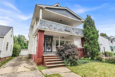 View of front of property featuring a garage, an outbuilding, a front yard, and covered porch | Image 2