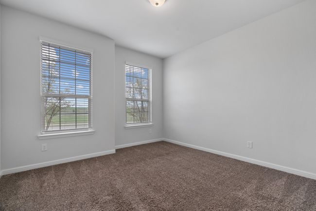 Spare room featuring baseboards and dark colored carpet | Image 19
