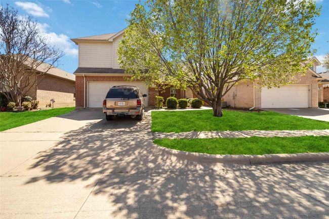 View of front facade with concrete driveway, a garage, brick siding, and a front yard | Image 5