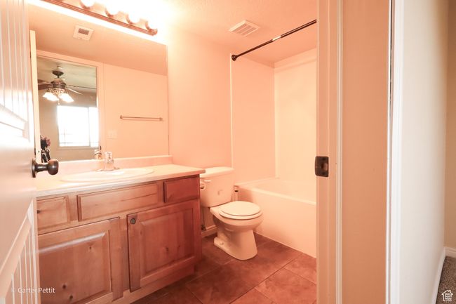 Bathroom with vanity, tile patterned floors, shower / tub combination, and ceiling fan | Image 17