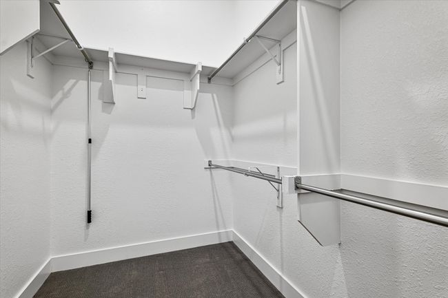 Walk in closet with dark carpet | Image 14