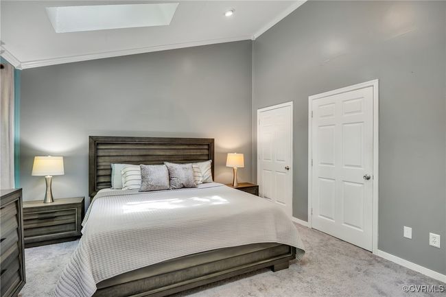 Bedroom featuring crown molding, a skylight, and carpet flooring, walk-in-closet, ensuite | Image 17