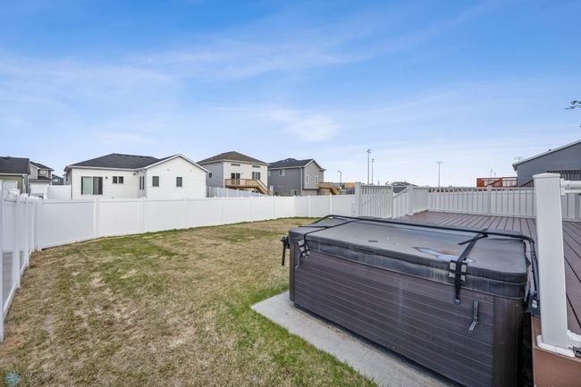 Fully fenced backyard with sprinkler, and concrete pad for included hot tub | Image 28