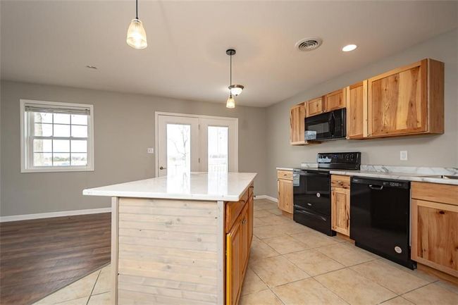 Kitchen with visible vents, black appliances, light countertops, and baseboards | Image 18