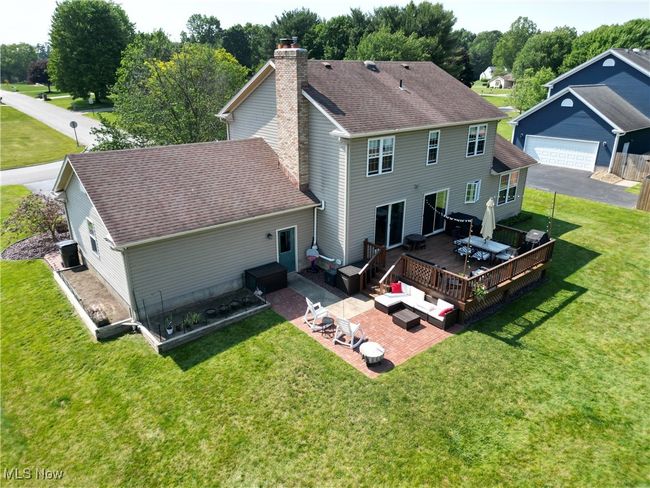 Back of property with a chimney, a wooden deck, a lawn, an outdoor hangout area, and a patio | Image 5