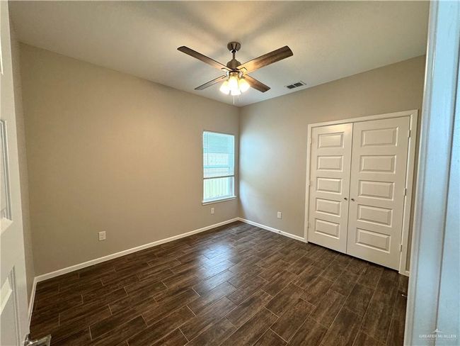 Unfurnished bedroom with dark wood finished floors, a closet, baseboards, and a ceiling fan | Image 7