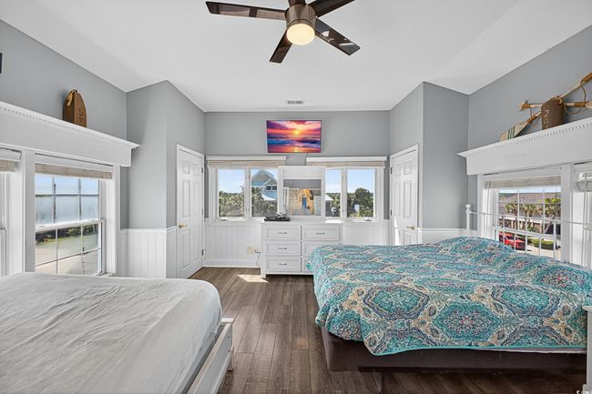 Bedroom featuring dark wood-style floors, multiple windows, wainscoting, and ceiling fan | Image 8