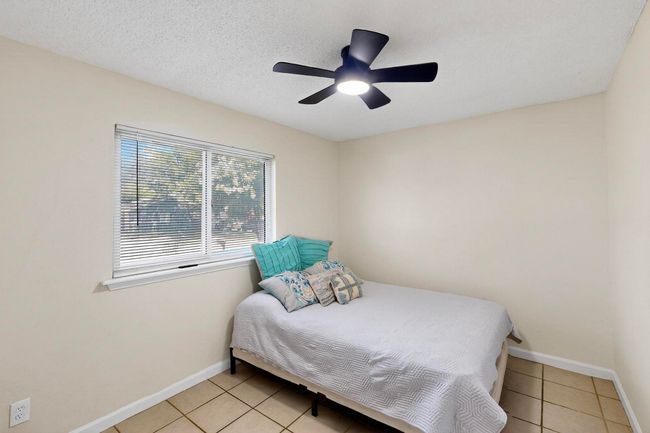 Bedroom with light tile patterned floors and ceiling fan | Image 16