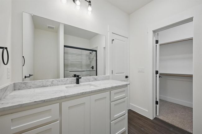 Full bathroom with vanity, baseboards, a stall shower, visible vents, and wood finished floors | Image 16