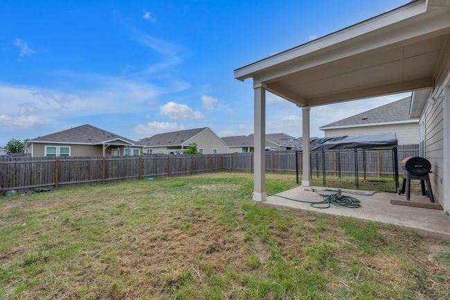 The covered patio offers a great spot for outdoor dining or lounging while enjoying the fenced backyard. | Image 24