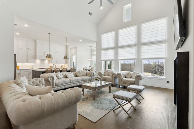 Living area featuring high vaulted ceiling, dark wood-style flooring, a ceiling fan, recessed lighting, and baseboards | Image 5