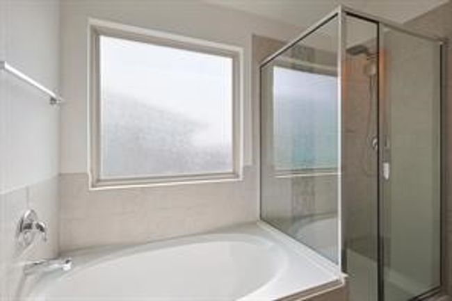 Bathroom featuring a shower stall and a garden tub | Image 11
