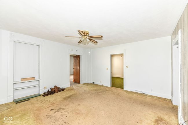 Living Room with hardwood floors under the carpet, room leads in to primary bedroom or bedroom 2 | Image 7