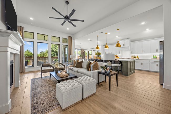 Living room with ceiling fan, light wood-style flooring, recessed lighting, and a glass covered fireplace | Image 6