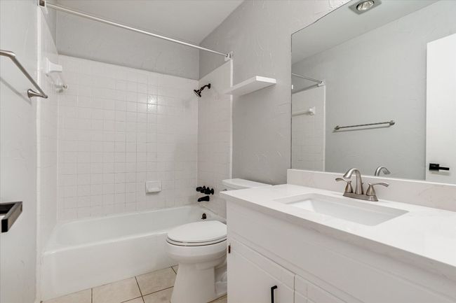 Full bath with toilet, tile patterned floors, bathing tub / shower combination, and vanity | Image 11