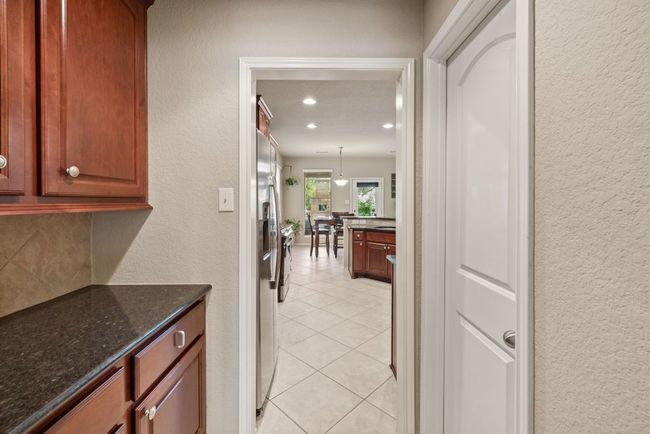 Corridor featuring a textured wall, light tile patterned floors, and recessed lighting | Image 8