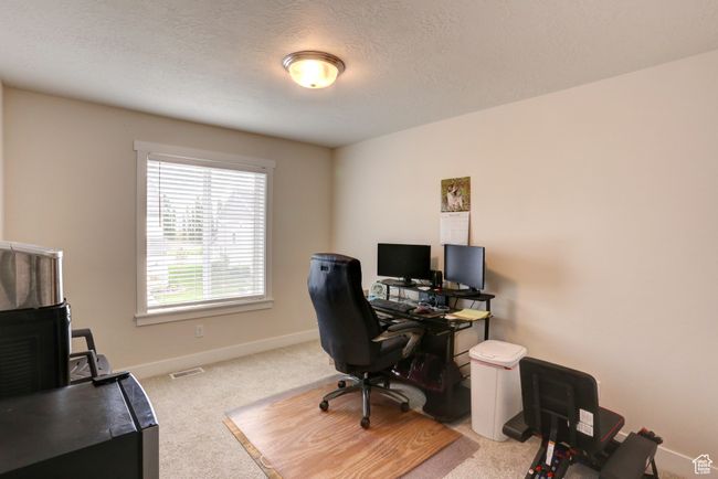 Carpeted office featuring a textured ceiling, baseboards, and visible vents | Image 19