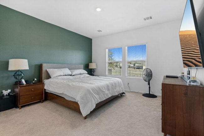 Bedroom with light colored carpet, visible vents, and baseboards | Image 16