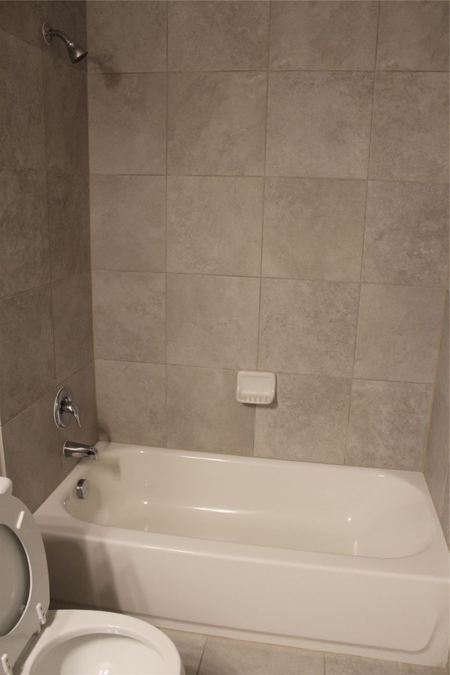Bathroom featuring toilet, bathtub / shower combination, and tile patterned floors | Image 19