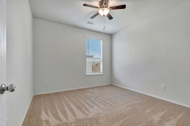 Carpeted empty room featuring ceiling fan and baseboards | Image 23