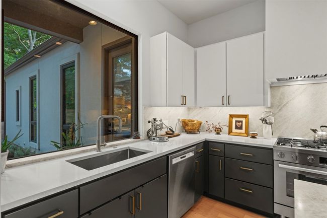 Kitchen featuring appliances with stainless steel finishes, light countertops, and white cabinetry | Image 17
