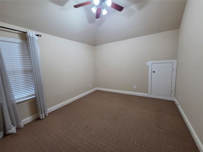 Empty room with lofted ceiling, a ceiling fan, and carpet | Image 24