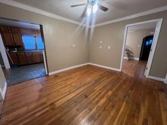 Unfurnished room featuring dark wood finished floors, crown molding, ceiling fan, and baseboards | Image 12