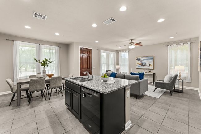 Kitchen featuring dark cabinetry, black dishwasher, healthy amount of natural light, light tile patterned flooring, and recessed lighting | Image 9