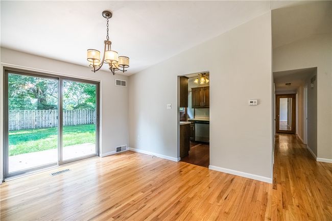 The bright dining room leads the way to the kitchen. | Image 7