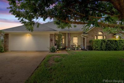 Ranch-style house featuring a garage and a yard | Image 1