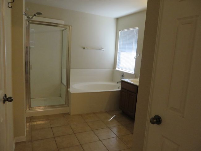 Full bath featuring vanity, a garden tub, a stall shower, and tile patterned floors | Image 10