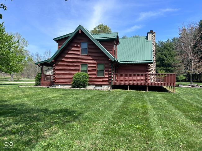 back of house featuring a lawn, a chimney, metal roof, and log exterior | Image 16