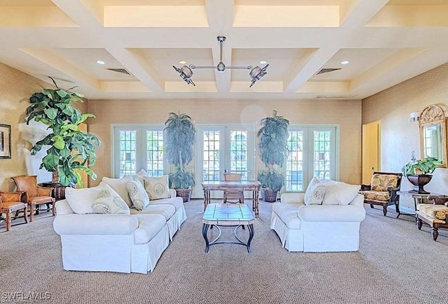 Carpeted living area featuring coffered ceiling, a chandelier, french doors, beamed ceiling, and recessed lighting | Image 29