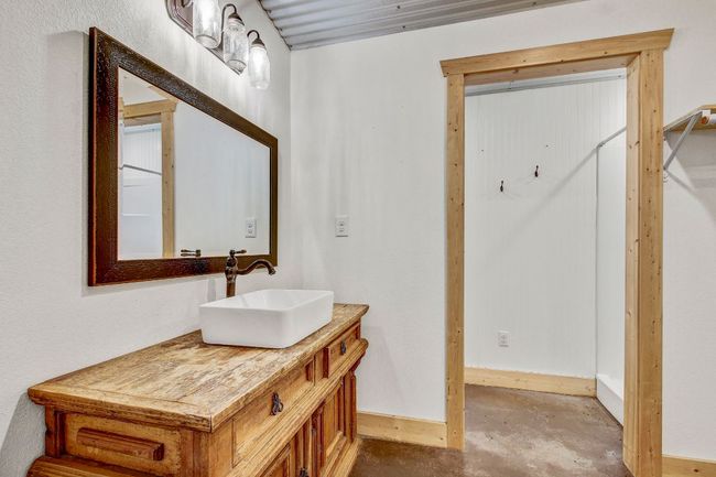 Bathroom with baseboards, unfinished concrete flooring, and vanity | Image 28