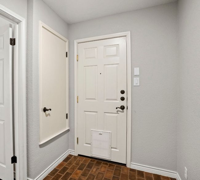 Garage entry featuring baseboards and brick patterned floors, washer & dryer included (not shown) | Image 25