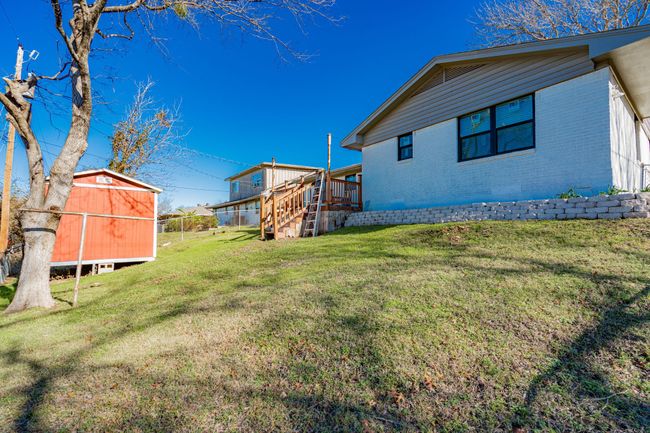View of grassy yard with a storage shed, a wooden deck, and stairway | Image 24