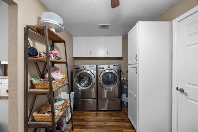 Washroom with independent washer and dryer, dark wood-style floors, cabinet space, a textured ceiling, and a ceiling fan | Image 15