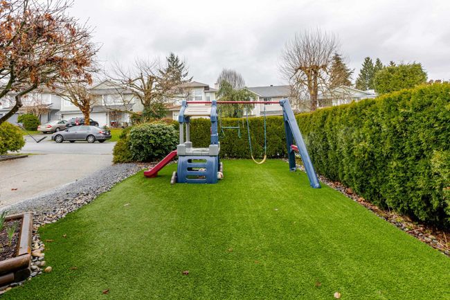 View of the front yard with grass turf and kids jungle gym | Image 34