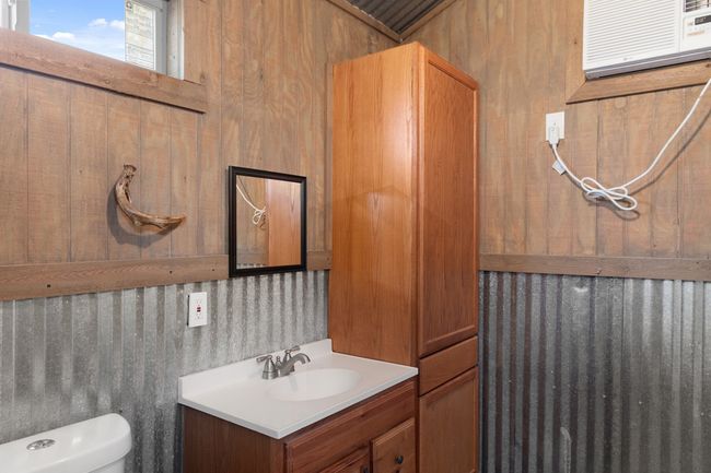 Bathroom featuring vanity, an AC wall unit, toilet, and wooden walls | Image 25